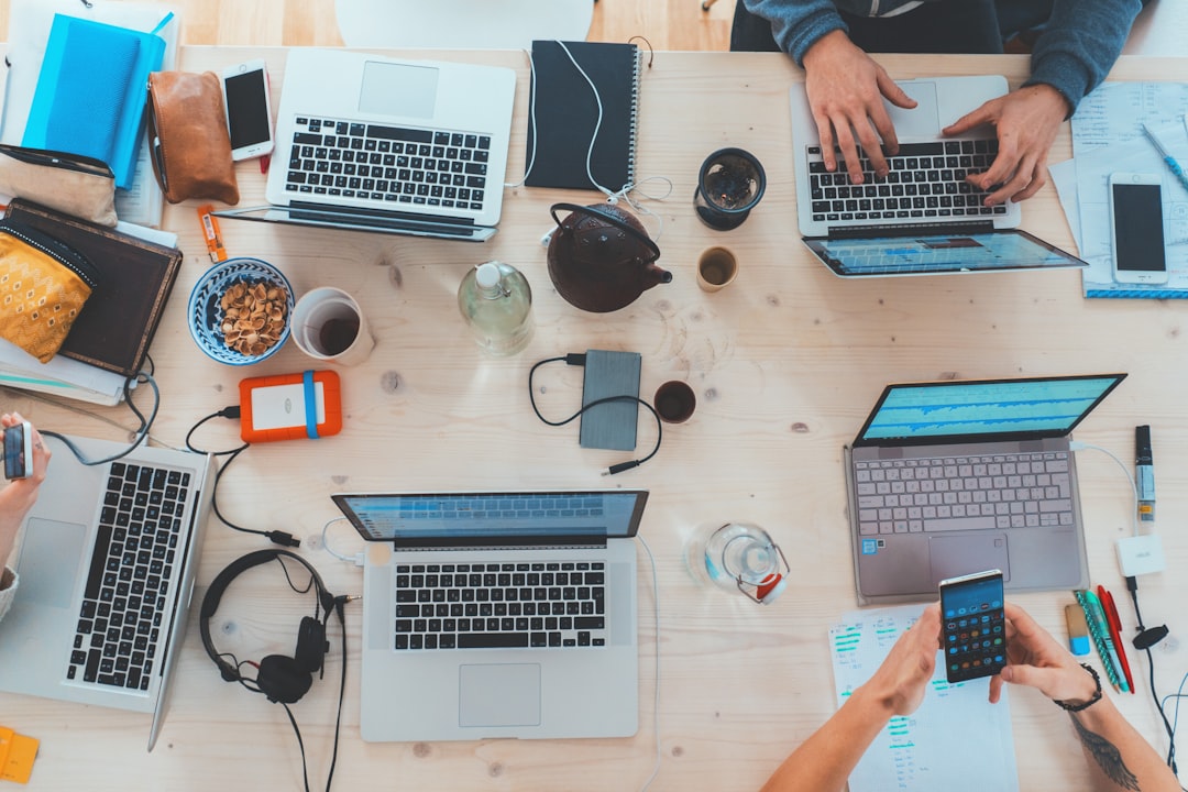 people-sitting-down-near-table-with-assorted-laptop-computers-syto3xs06fu